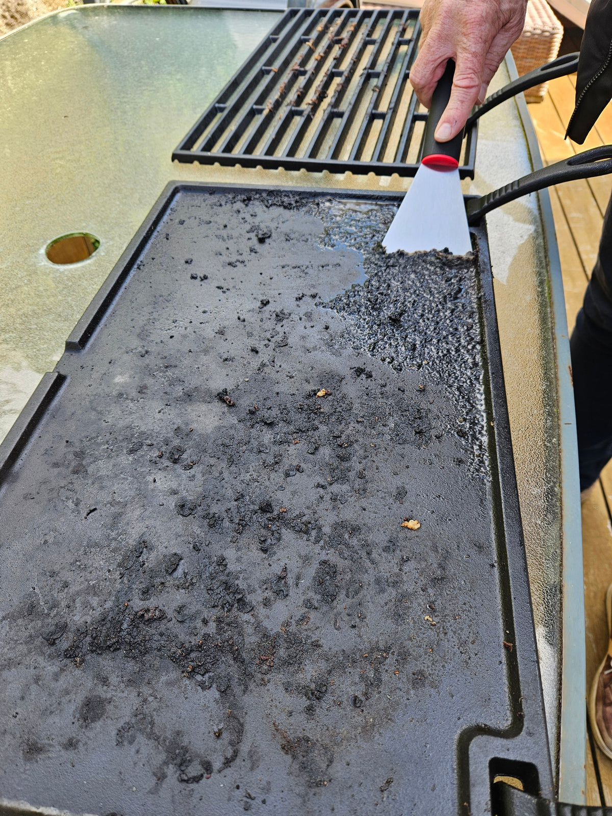 Scraping food residue from a Buschbeck cast iron hotplate.